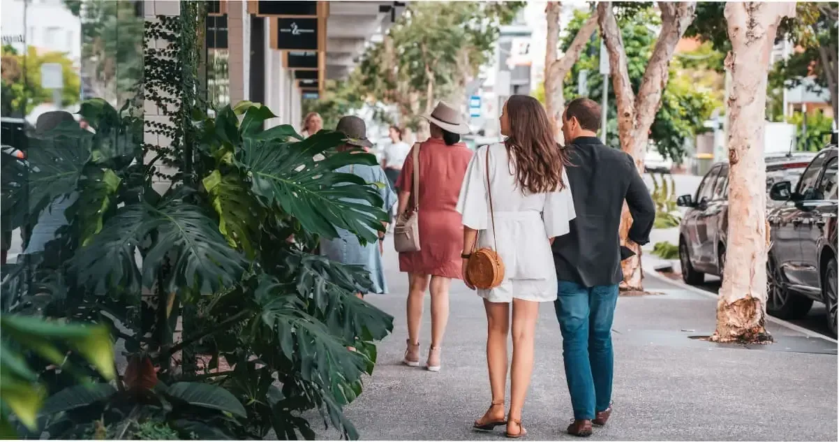 A couple walking past the greenery on James Street, Brisbane