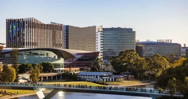 Adelaide city centre along the River Torrens, surrounded by lush greenery and modern buildings