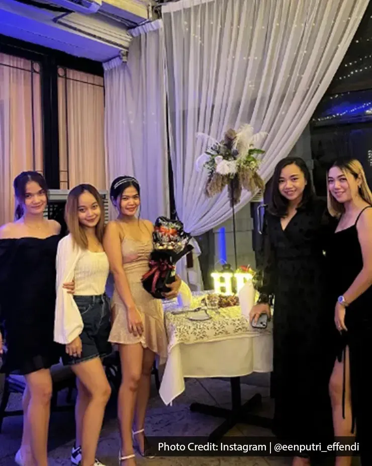 Group of women posing at a decorated celebration table in Beach Blanket Babylon.