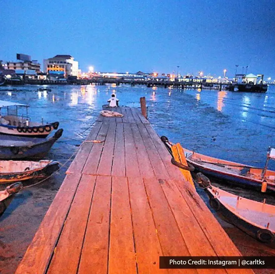 Peaceful waterfront view with wooden jetty and boats at Clan Jetty.