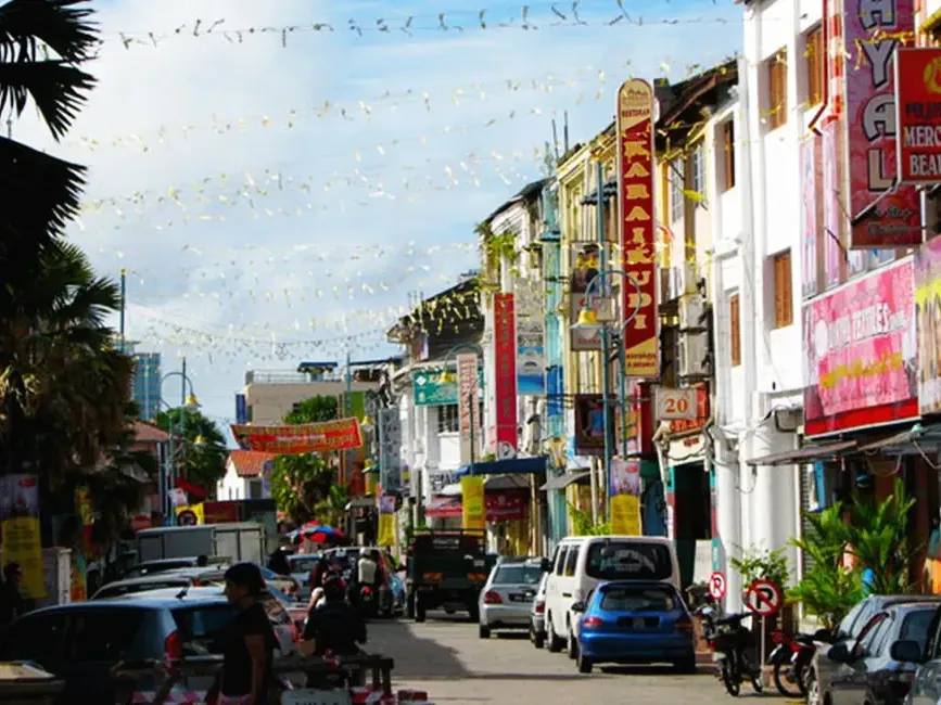 A bustling street filled with numerous cars and motorcycles navigating through traffic - Lexis Suites Penang