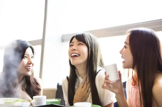 Group of friends enjoying a meal and chatting together - Lexis Hotels & Resorts