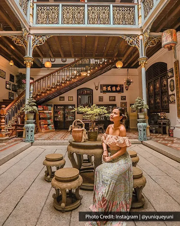 Woman posing in Pinang Peranakan Mansion with antique decor – Lexis Suites Penang