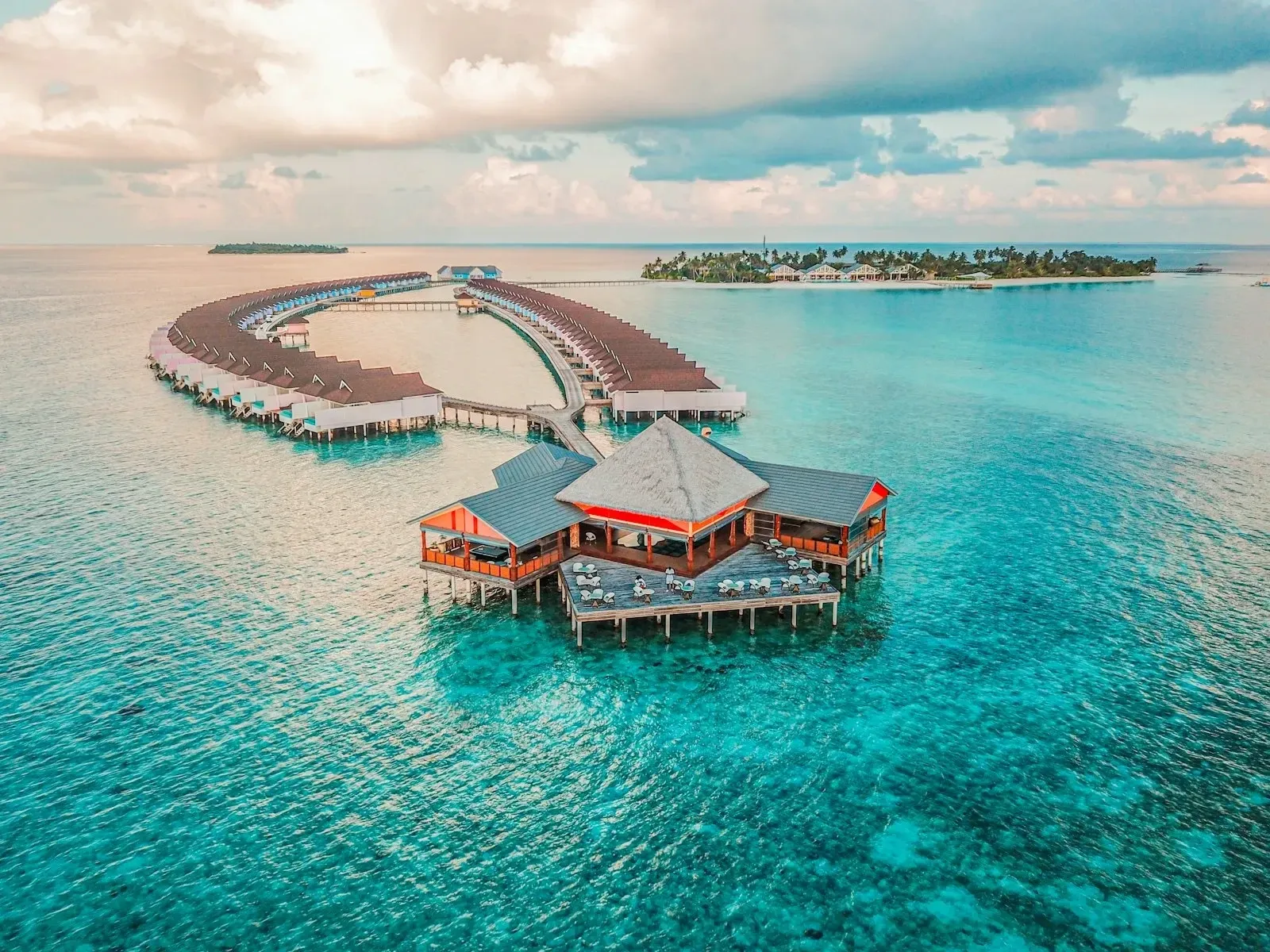 An aerial view of a turquoise lagoon winding past waterfront terraces