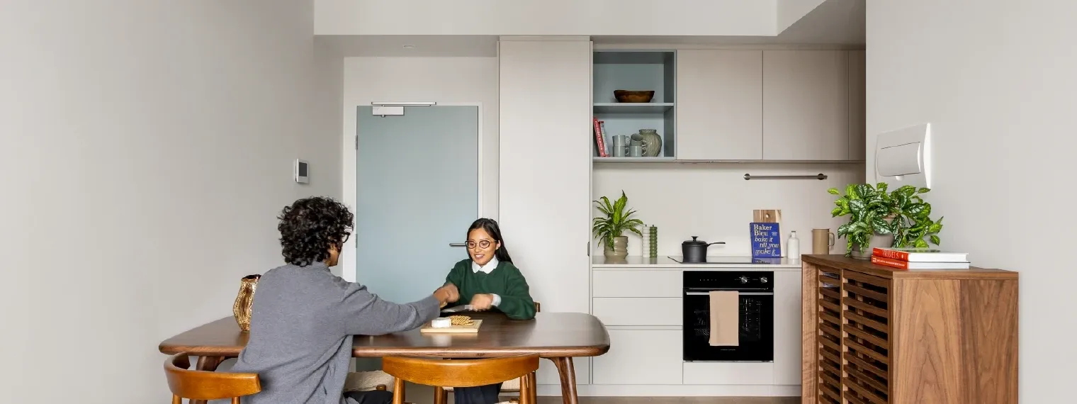 Couple seated at dining table in a 1 Bedroom Apartment at Swift Walk in Kensington.
