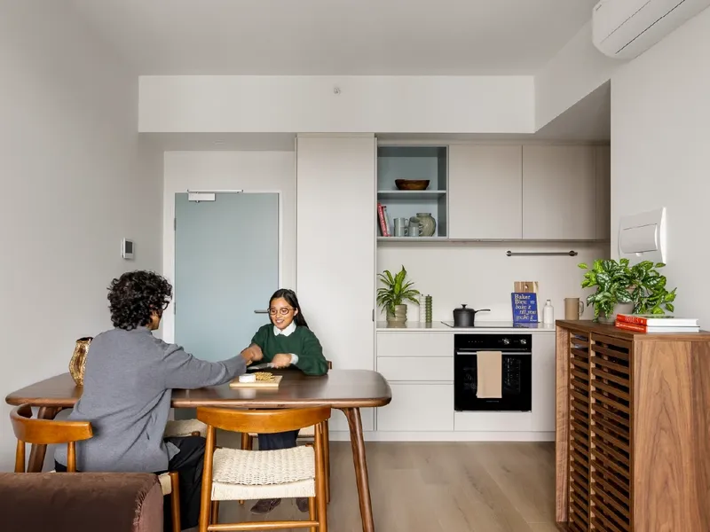 Couple seated at dining table in a 1 Bedroom Apartment at Swift Walk in Kensington.