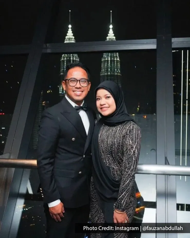 A couple poses together in front of the Petronas Towers, capturing a moment at the famous Kuala Lumpur landmark.