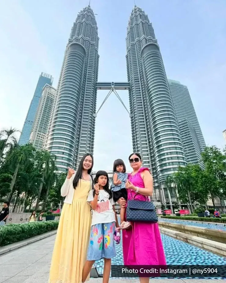 Family posing in front of the Petronas Twin Towers in Kuala Lumpur