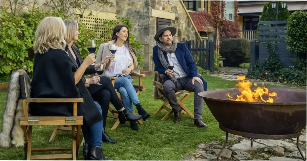 A group of people gathered around a fire at Mount Lofty House in The Adelaide Hills