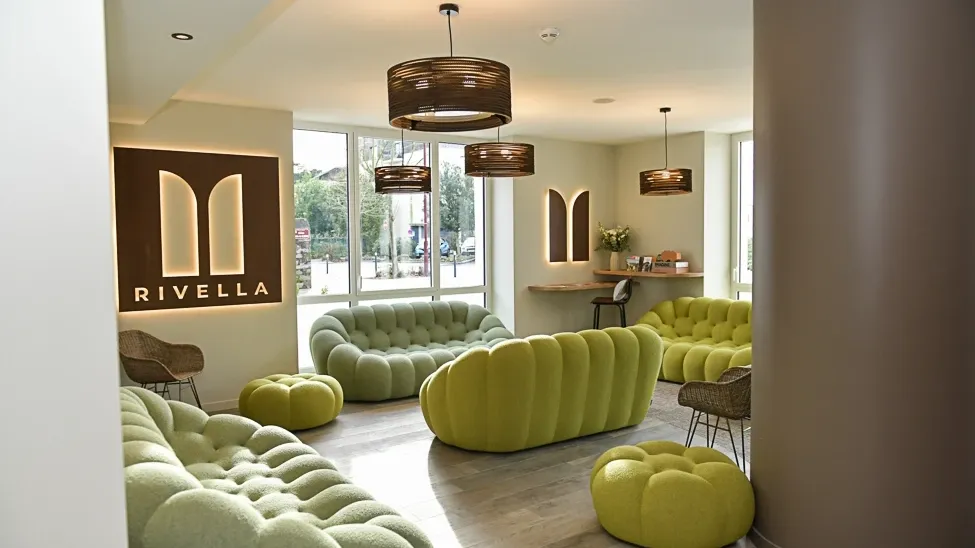 Modern lounge area with green couches and unique design elements at Hôtel Rivella.