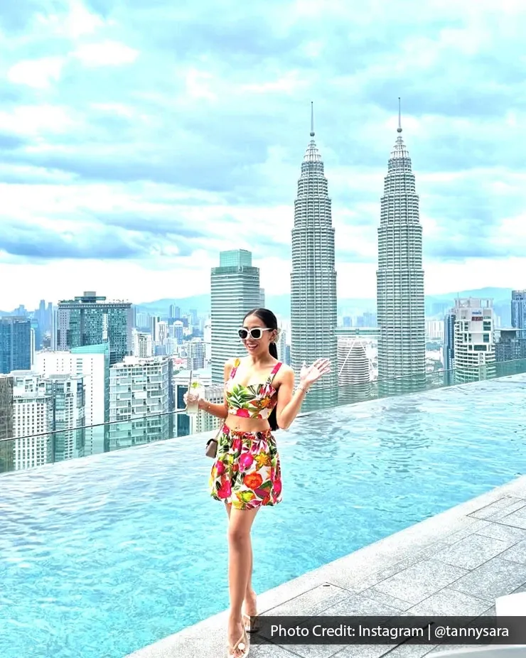 A woman in a floral dress celebrating her birthday at an infinity pool in Kuala Lumpur.