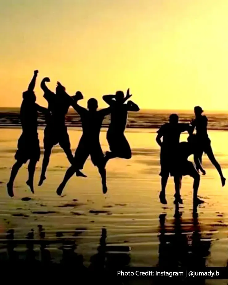 Silhouettes of people jumping at the beach with reflections on wet sand at sunset - Lexis Hibiscus Port Dickson
