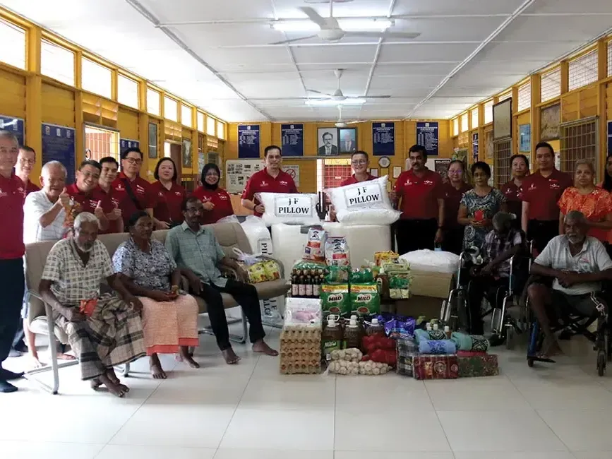 A group of people surrounded by essential donations and posing for the photo - Lexis Hotels & Resorts
