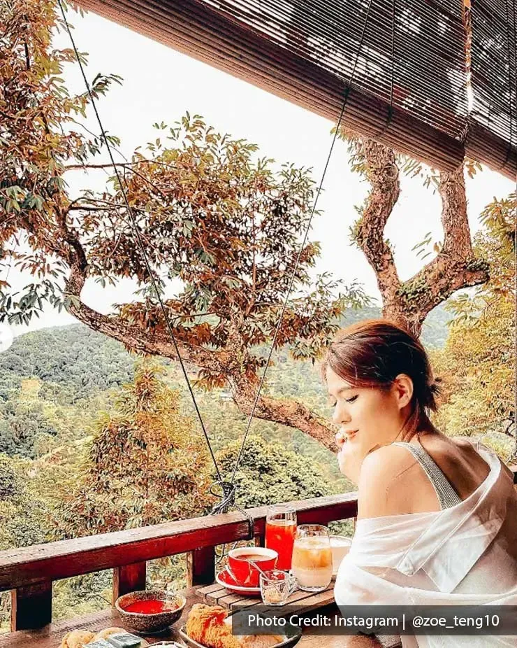 A lady was taking a picture with her dishes at Bao Sheng Durian Farm - Lexis Suites Penang