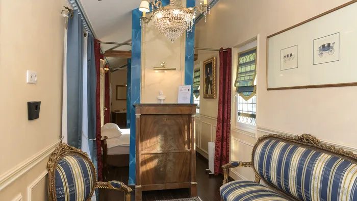 Élégant salon avec mobilier classique, lustre et œuvres d'art à l'Hôtel Villa Aultia.