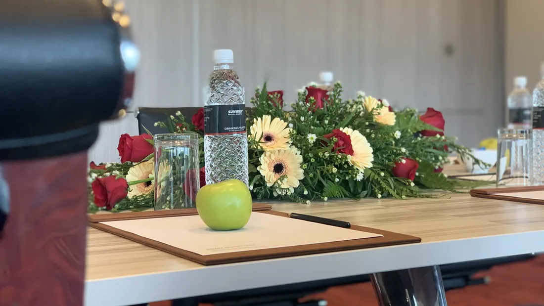 Meeting table with flowers, apple, and notepad for Meeting and Event Packages.