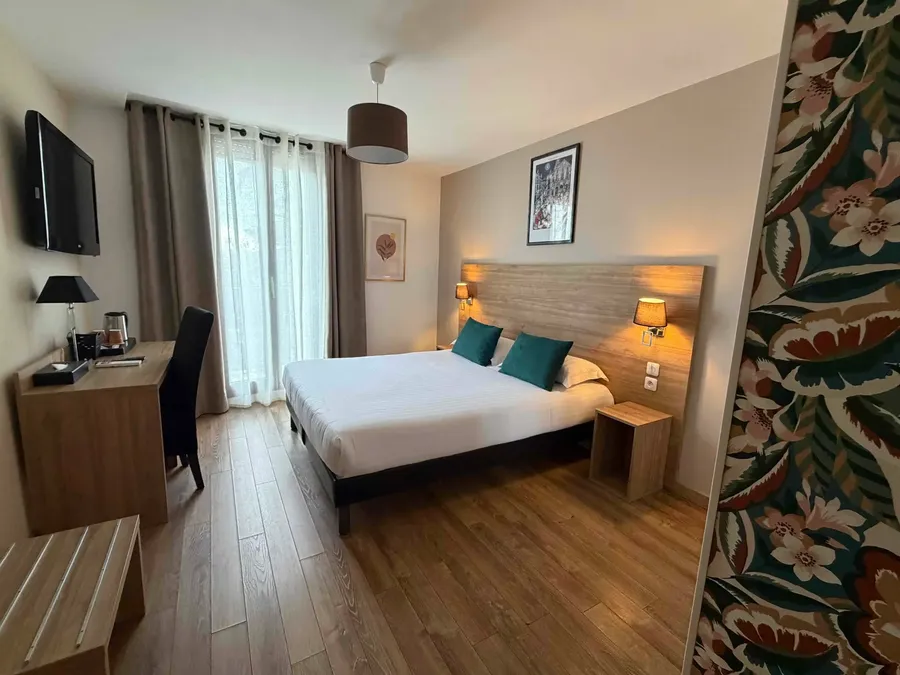 Chambre confort avec lit double, bureau, et télévision au Le Grand Hôtel Molière à Pézenas.