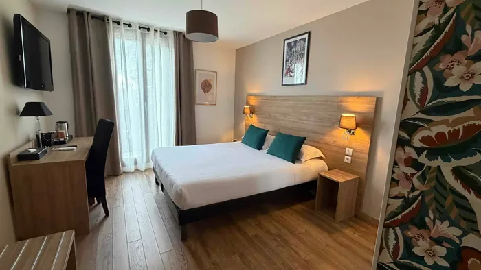 Chambre élégante avec lit double et bureau au Grand Hôtel Molière.