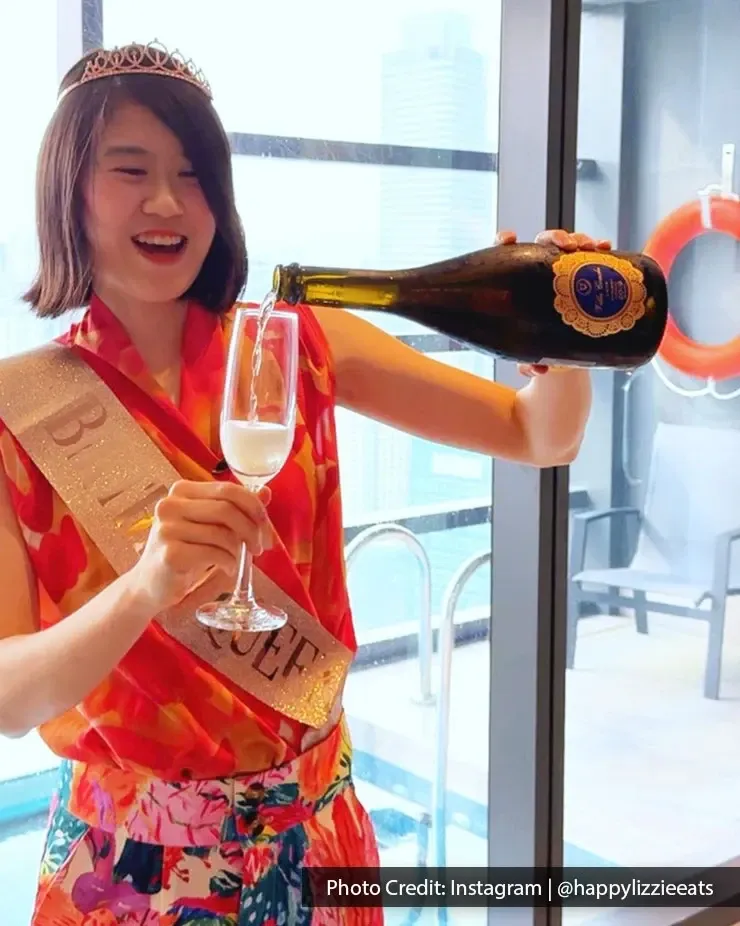Birthday girl pouring champagne and enjoying her birthday celebration by the hotel pool.