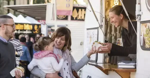 A family buys some food from a vendor at Salamanca Market.