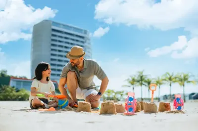 Father and child enjoying sandcastle fun on the beach - Lexis Hibiscus Port Dickson