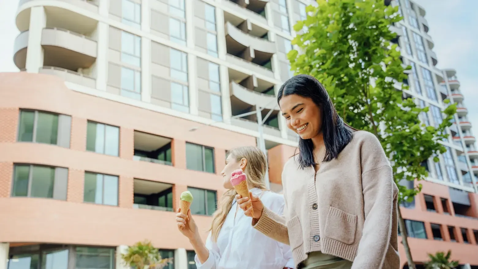Two women holding ice creams in front of Caulfield Place building.