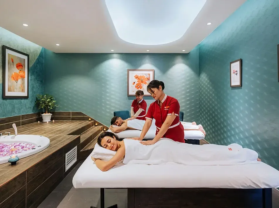 A couple enjoying a wellness retreat provided by professionals in a spa room - Lexis MY