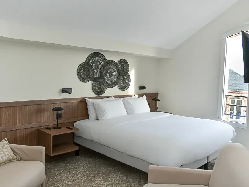 Chambre familiale avec lit double et canapés à l'Hôtel Rivella de Clisson.