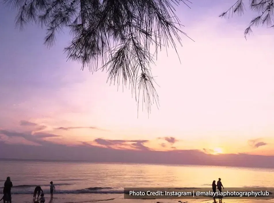 Tourist strolling by the beach with sunset view