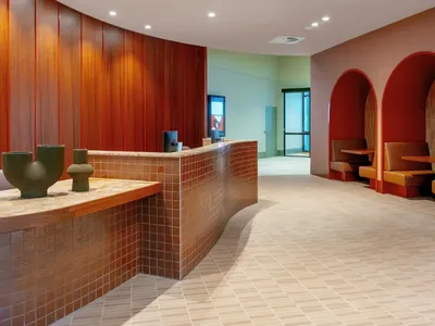 Caulfield Place lobby with wooden walls, curved archways, and modern furniture.