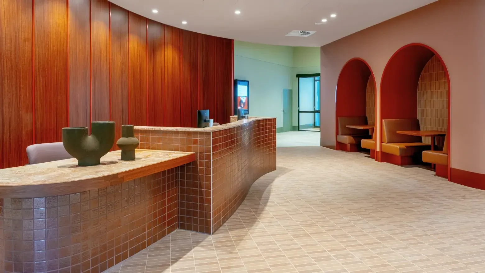 Caulfield Place lobby with wooden walls, curved archways, and modern furniture.