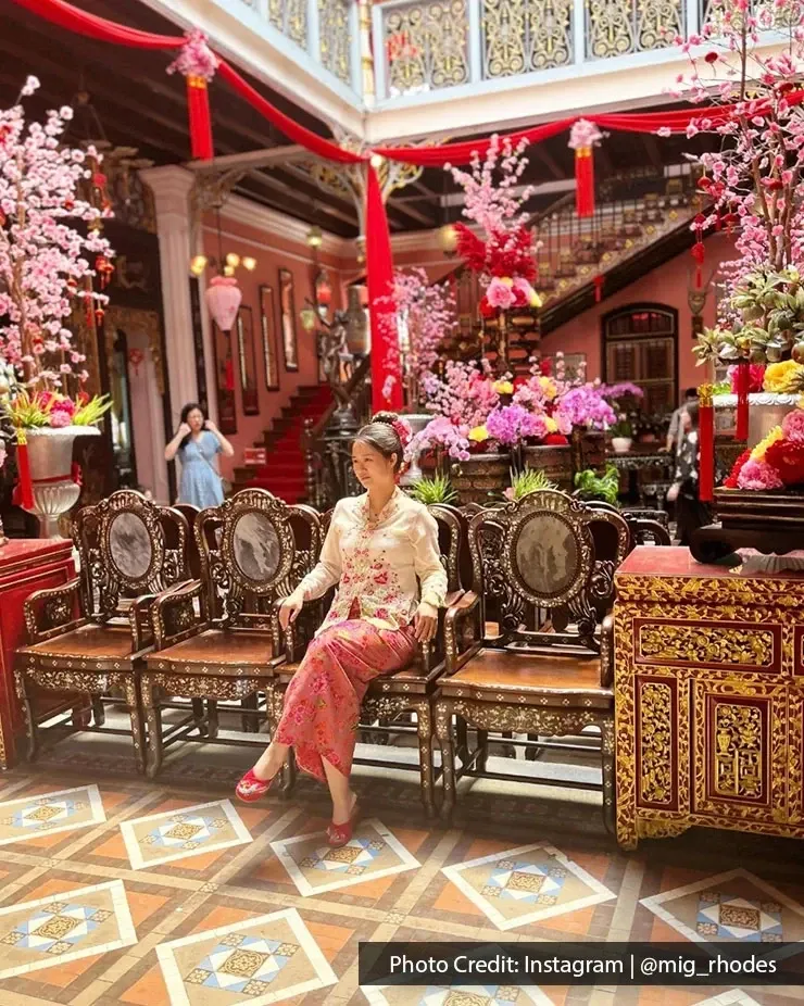 Traditional Nyonya outfit woman posing at Pinang Peranakan Mansion in George Town Penang.