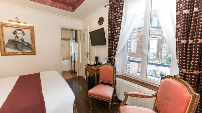 Chambre élégante avec lit, fauteuils, télévision et vue depuis la fenêtre à l'Hôtel Villa Aultia.