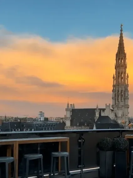 Scenic rooftop view of the historic city skyline and tower placed by an open terrace at Warwick Grand Place Brussels