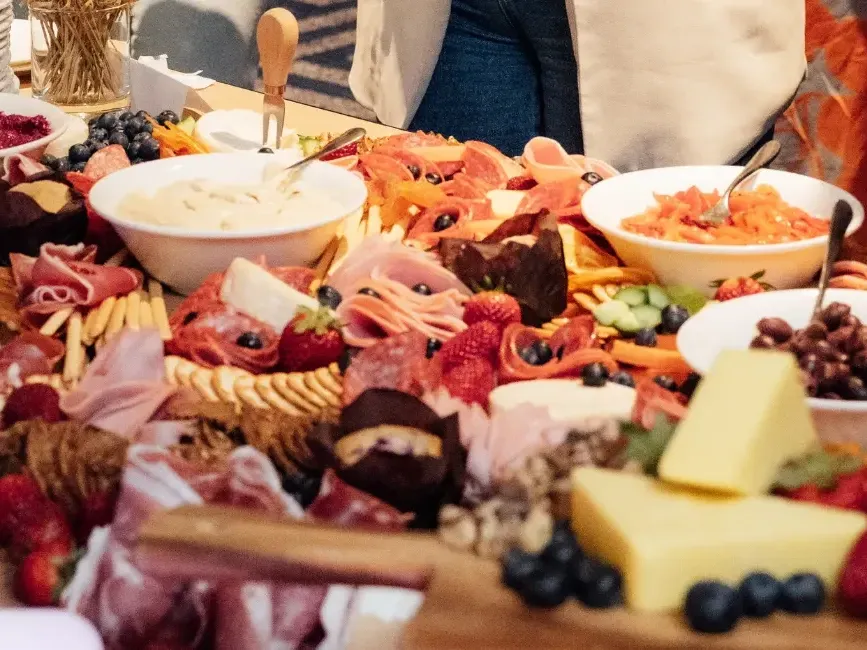 Elaborate charcuterie board with assorted cheeses, cured meats, fresh berries, crackers, and dips for Premium Cocktail Package