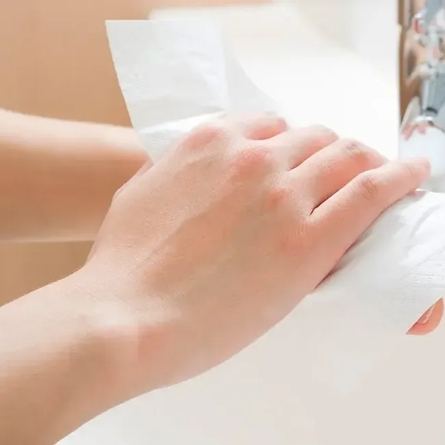A person drying their hands with a paper towel - Imperial Lexis Kuala Lumpur