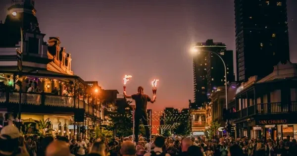 Adelaide Fringe street performer above a crowded street at dusk