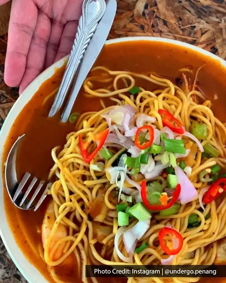 Bowl of Salwa Mee Udang with prawns, red chili, and fresh garnishes