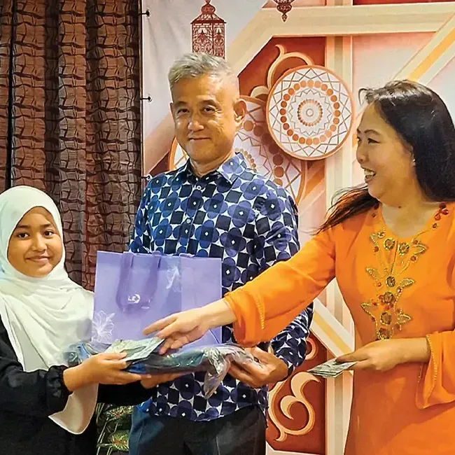 General managers of Lexis Hibiscus PD and Grand Lexis PD handing out raya packets to children - Lexis Hotels & Resorts