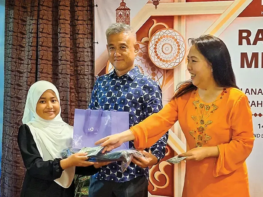 General managers of Lexis Hibiscus PD and Grand Lexis PD handing out raya packets to children - Lexis Hotels & Resorts