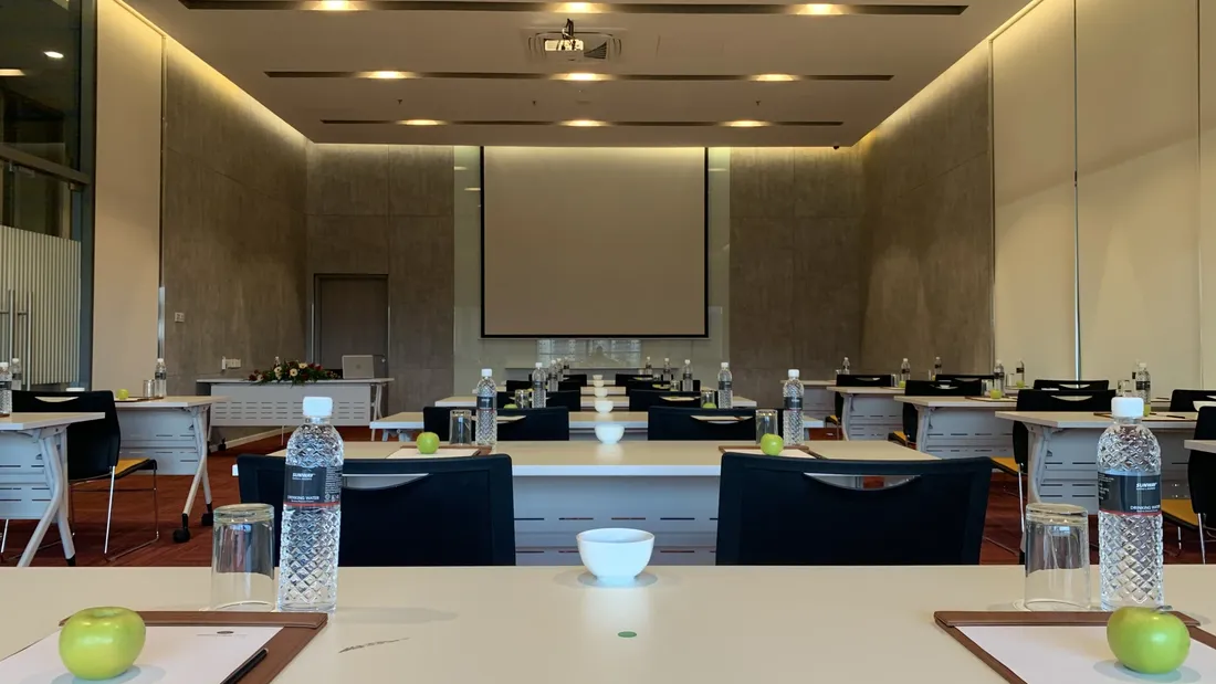 Meeting and Event Packages setup with water bottles and apples on tables.