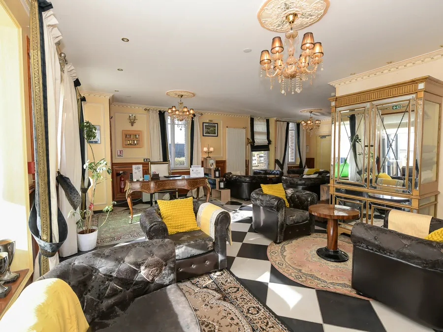 Salon élégant avec meubles noirs et coussins jaunes à l'Hôtel Villa Aultia.