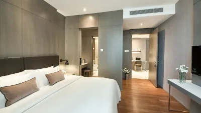 TV facing the cozy bed in 1-Bedroom Executive with wooden flooring at VE Hotel & Residence