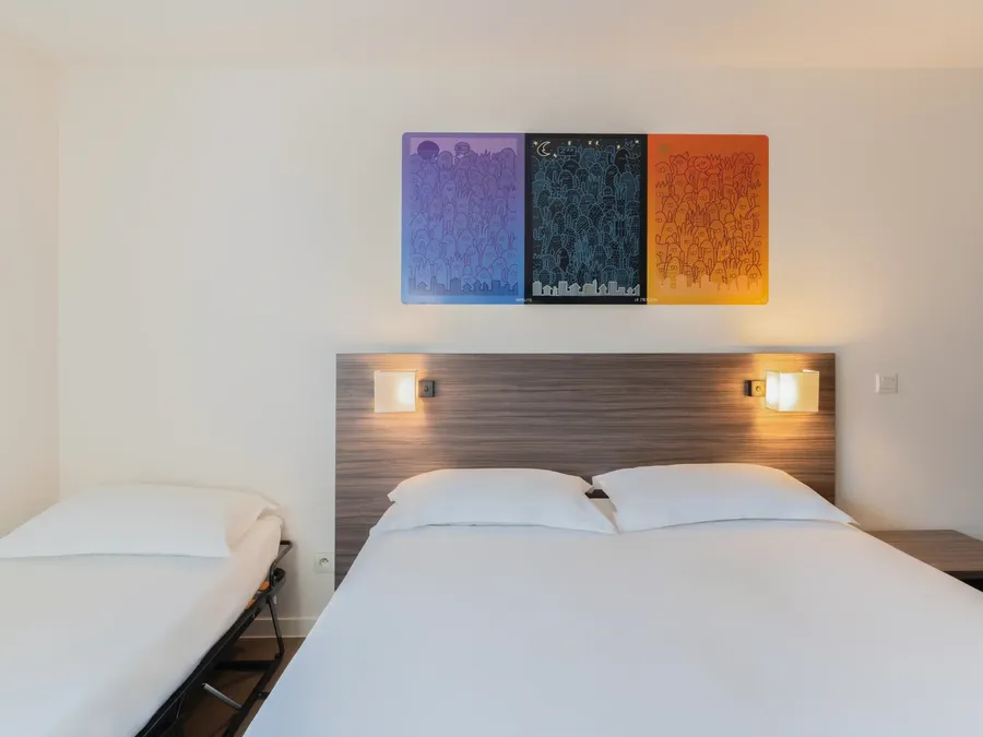 Modern Triple Studio room with two beds and artwork at Appart’Hôtel Hévéa in Valence.
