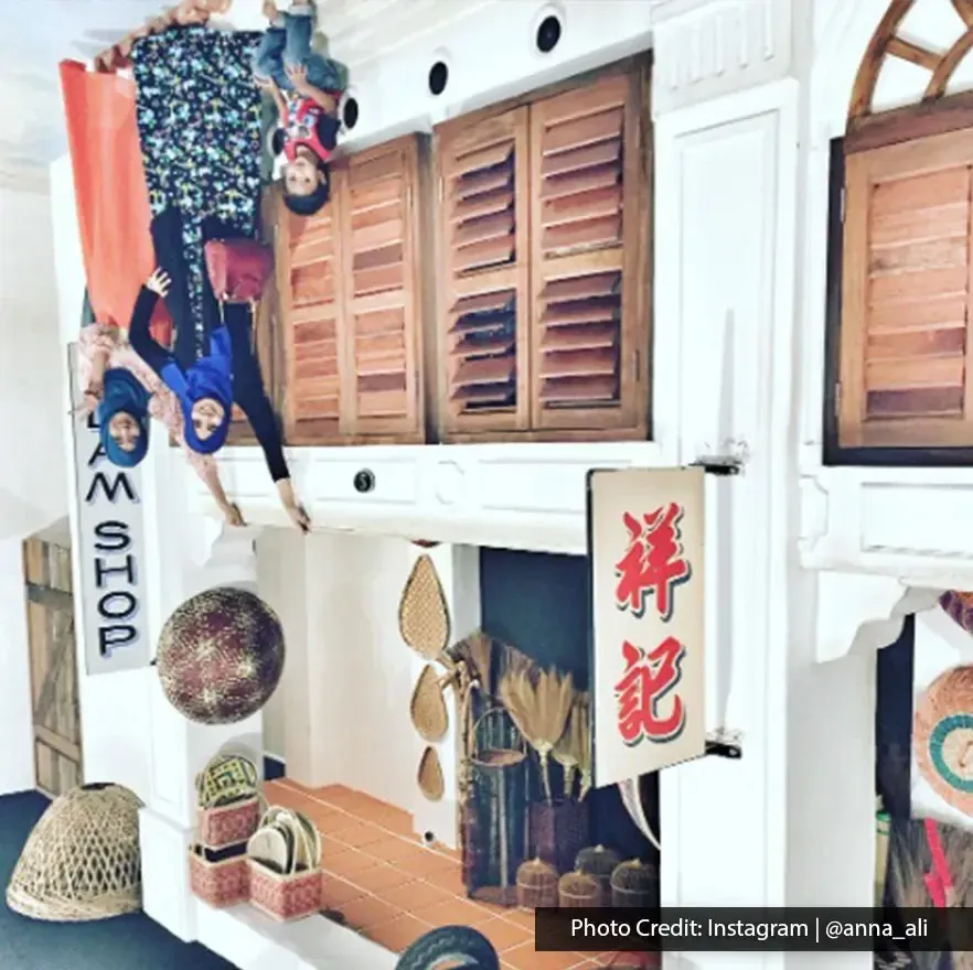 Visitors posing in a vintage shop setup at Upside Down Museum.