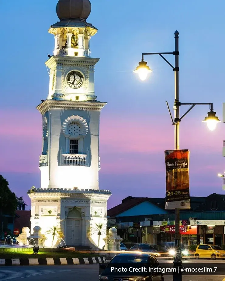 Night view of Queen Victoria Memorial Clock Tower with city street.