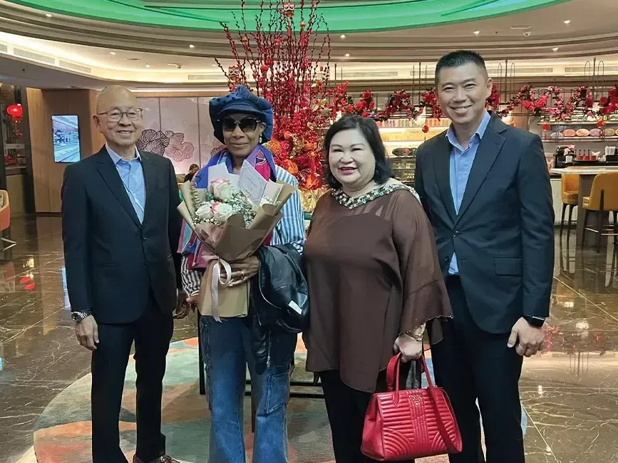 Four individuals posing in a hotel lobby - Lexis Hotels & Resorts