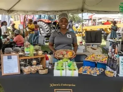 Kiara\'s Enterprise promo banner showing a woman holding a basket of baked goods under a tent near Jamaica Pegasus Hotel