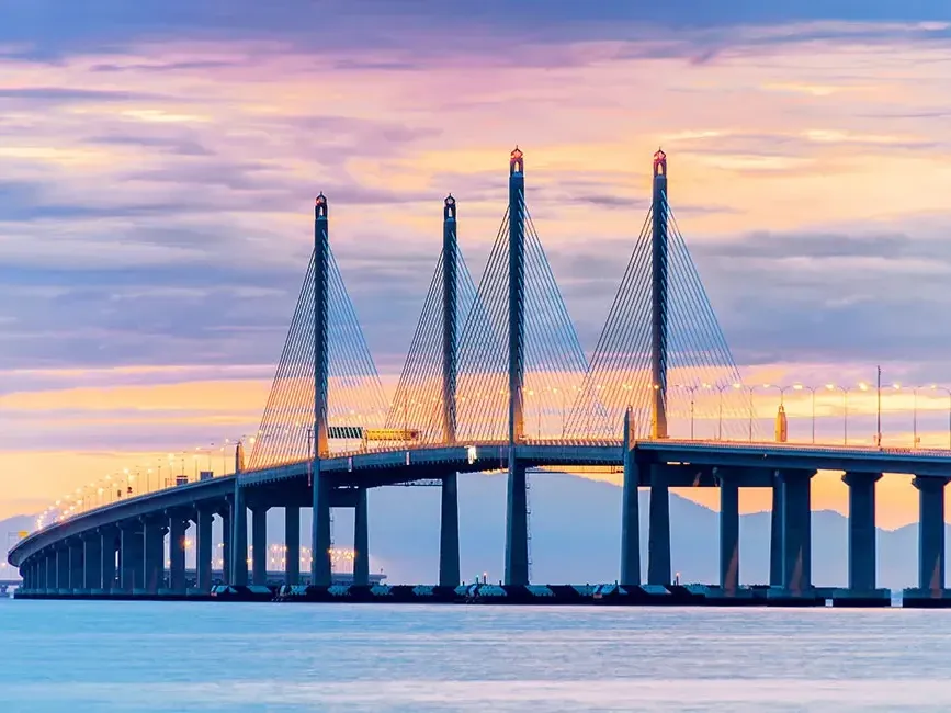 Golden hour view of Penang Bridge across still waters - Lexis Suites Penang