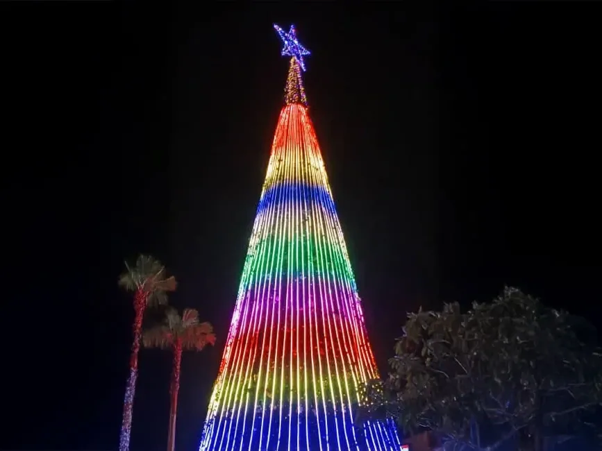 A large Christmas tree adorned with vibrant rainbow-colored lights - Lexis Hotel Group